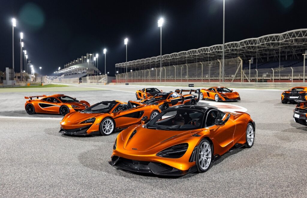 Modern McLaren road cars in Mansour Orange lined up on circuit
