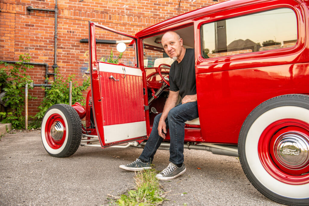 Brian Jones sitting in his custom 1928 Ford Model A hot rod