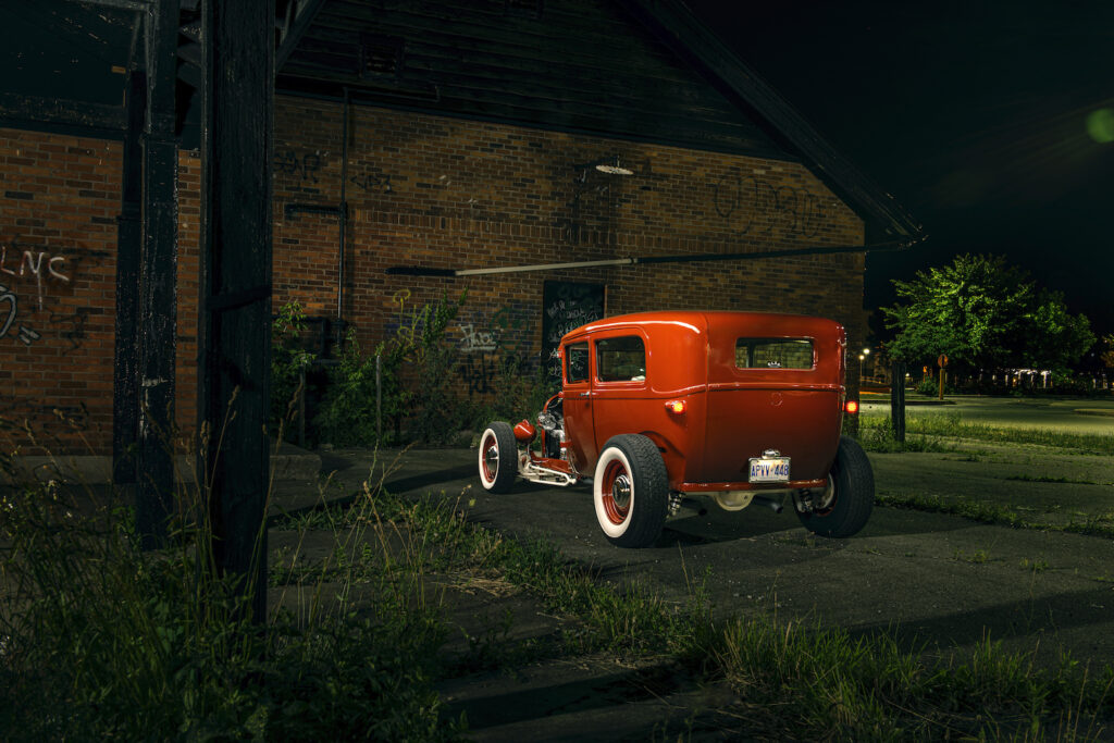 Rear view of a red 1928 Ford Model A hot rod parked at night