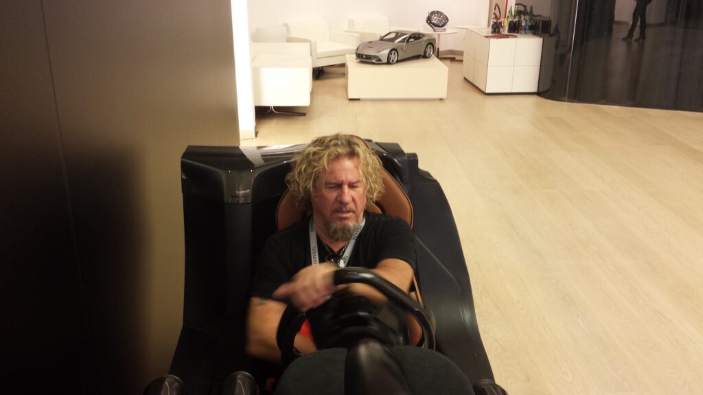 Sammy Hagar sitting in a Ferrari driving simulator.