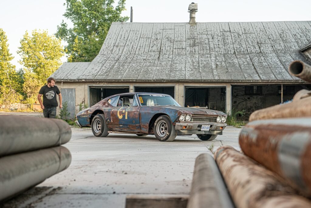 Patina 1968 Chevrolet Chevelle race car parked outside rural barn garage