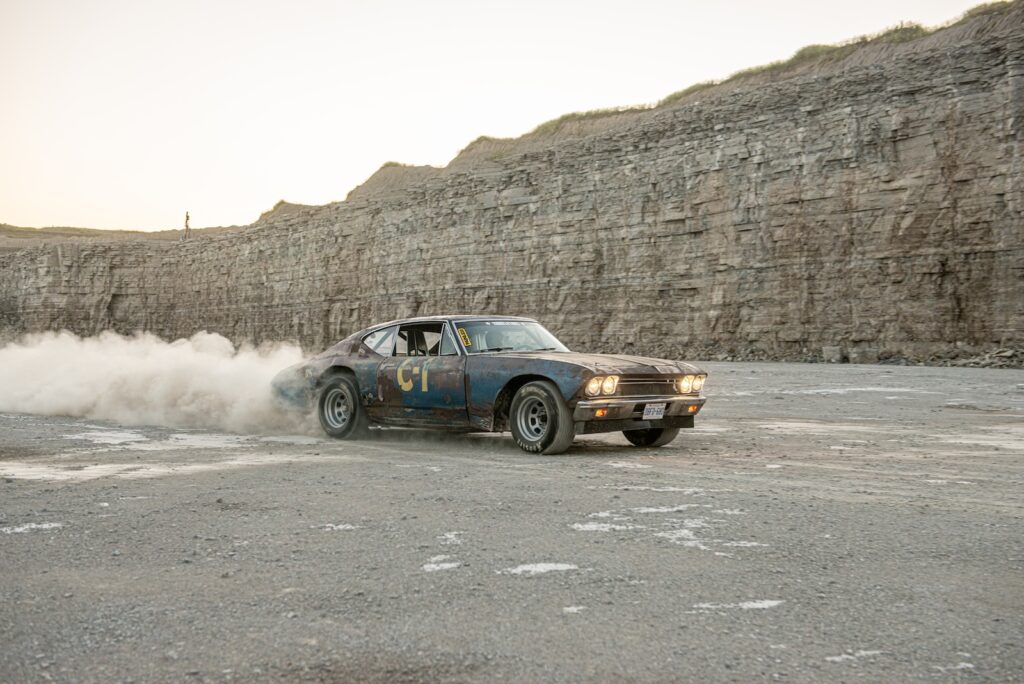 Weathered 1968 Chevrolet Chevelle drifting on gravel quarry surface
