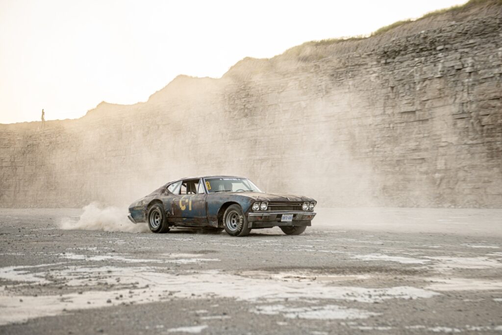 1968 Chevrolet Chevelle kicking up dust while driving across quarry