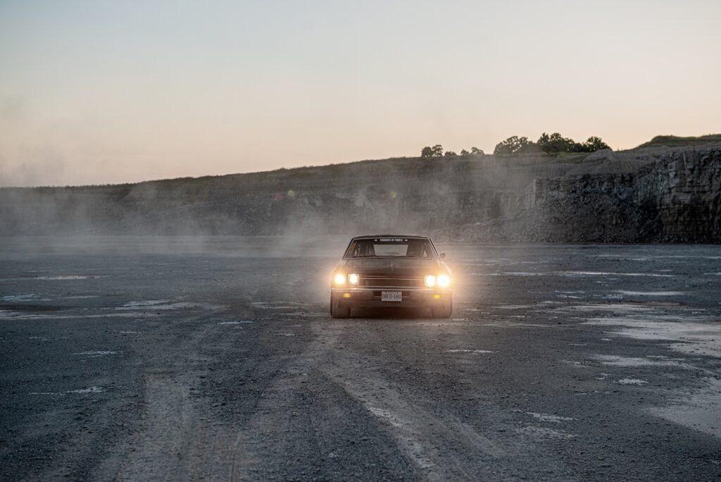 Front view of 1968 Chevrolet Chevelle driving through dust on quarry floor