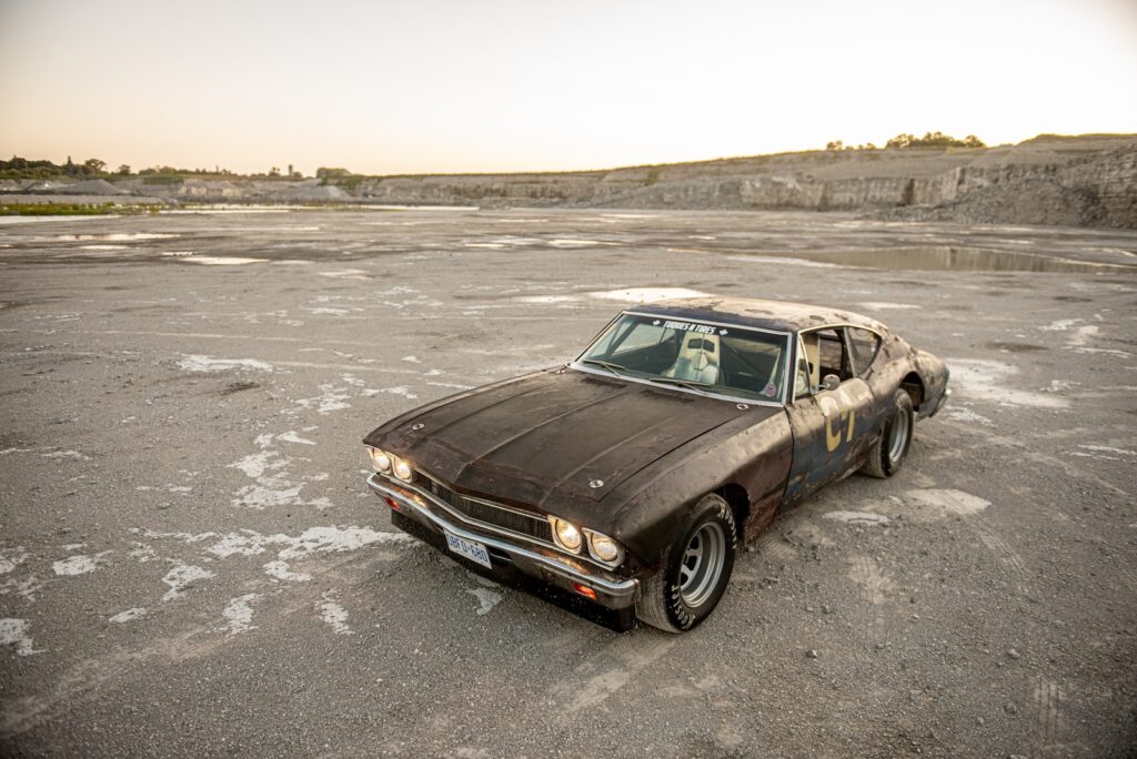 High-angle view of weathered 1968 Chevrolet Chevelle on gravel quarry floor