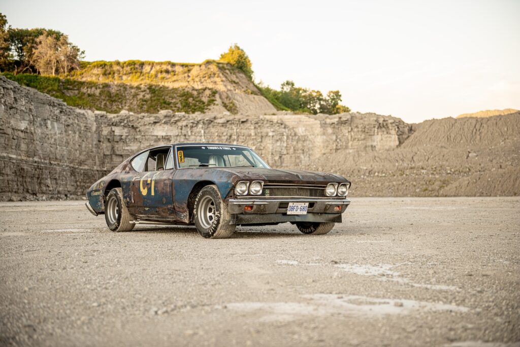 Weathered 1968 Chevrolet Chevelle race car parked on gravel quarry floor