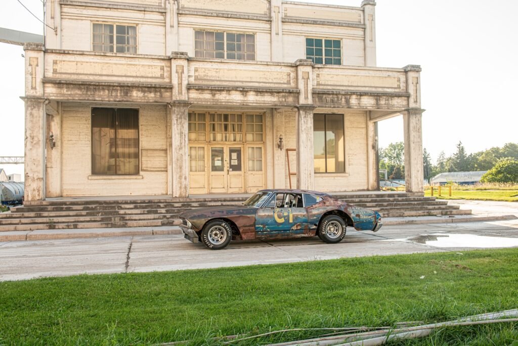 1968 Chevrolet Chevelle race car parked in front of weathered industrial building