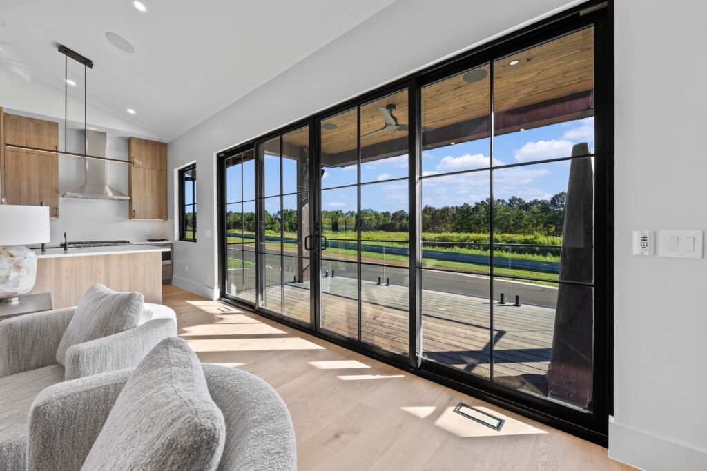 Modern motorclub residence interior with large sliding glass doors overlooking racetrack