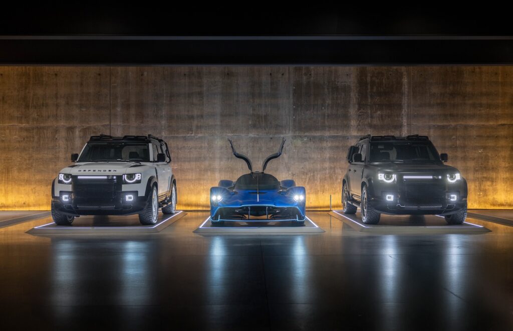 Artemis Automotive Defenders flanking hypercar in modern illuminated showroom