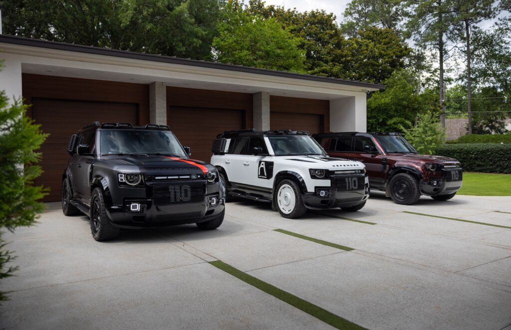 Three Artemis Automotive Land Rover Defenders parked outside modern luxury home