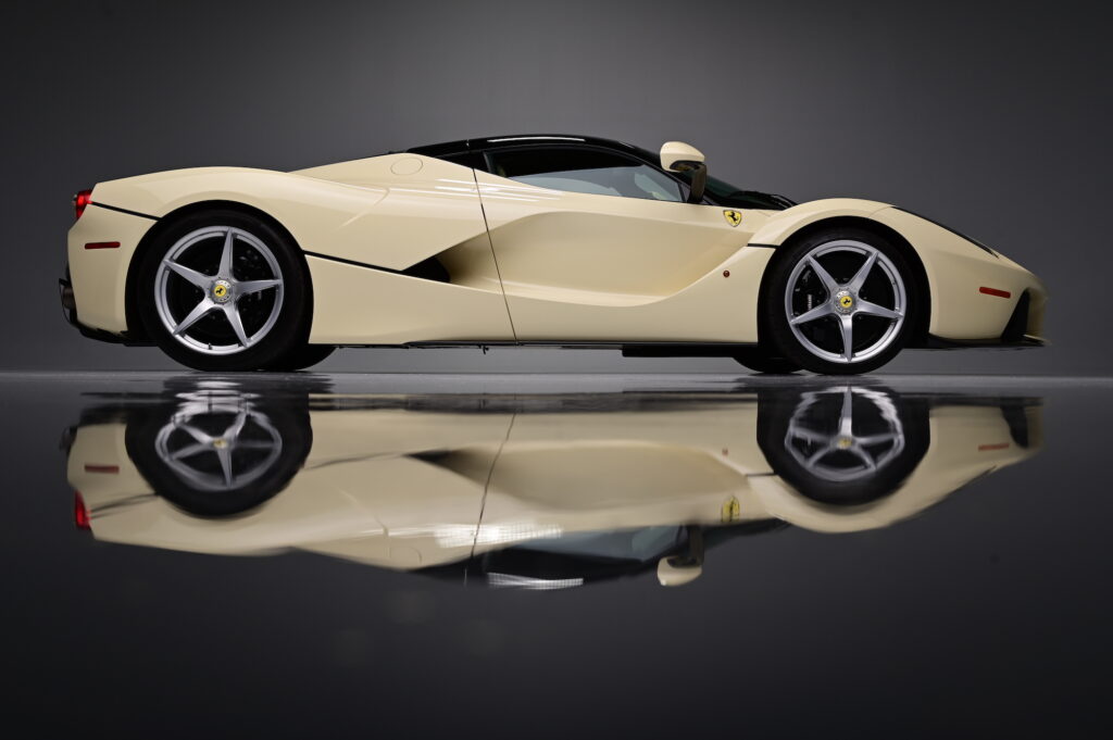 Side profile of a cream Ferrari LaFerrari photographed in dramatic lighting.