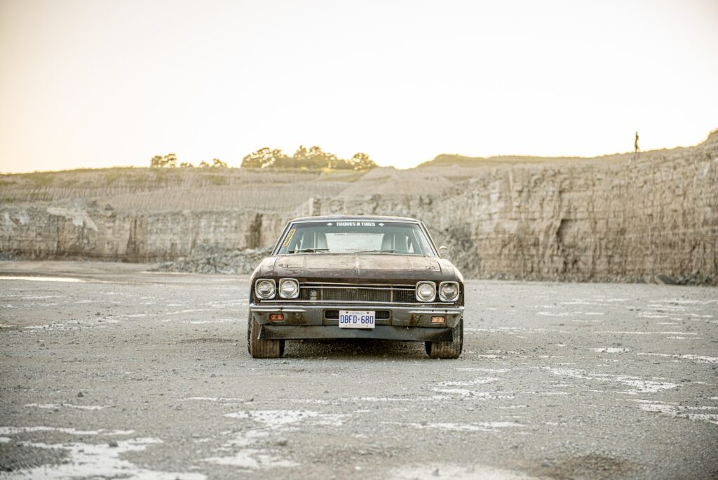 Front view of weathered 1968 Chevrolet Chevelle race car parked on gravel