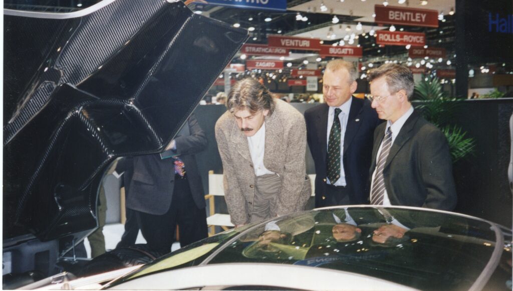 Horacio Pagani standing beside early Pagani car display