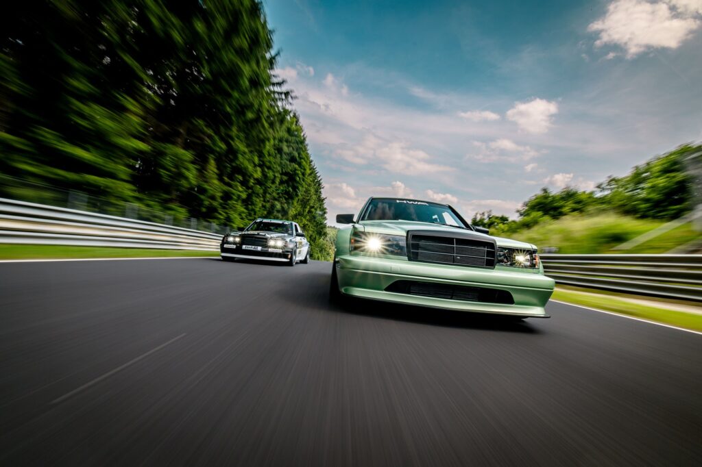 HWA EVO and Mercedes 190E driving on track front three-quarter