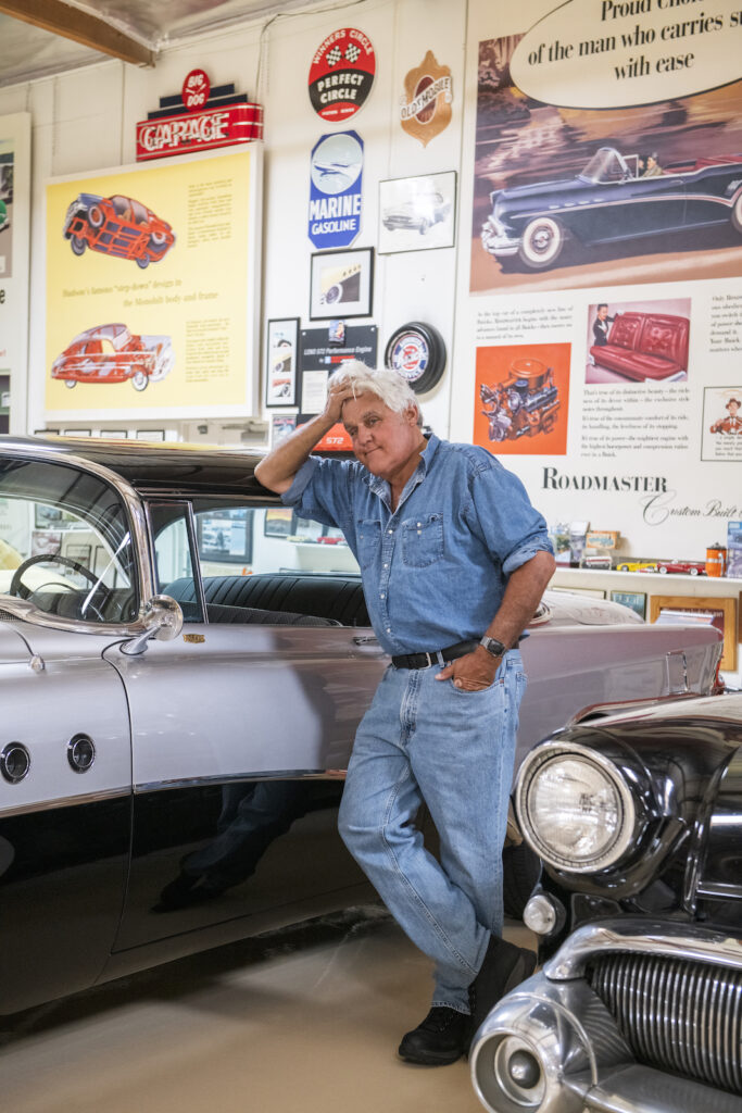 Jay Leno leaning on vintage car