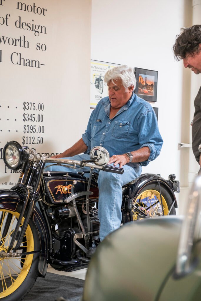 Jay Leno sitting on vintage motorcycle