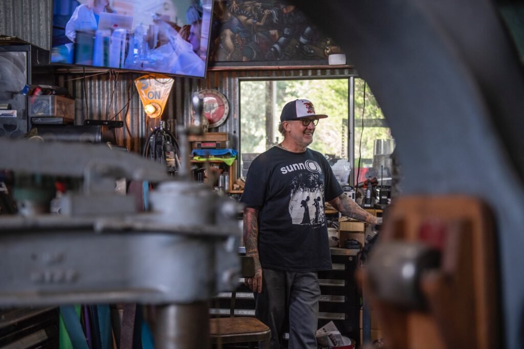 Jesse James smiling inside his metal fabrication workshop