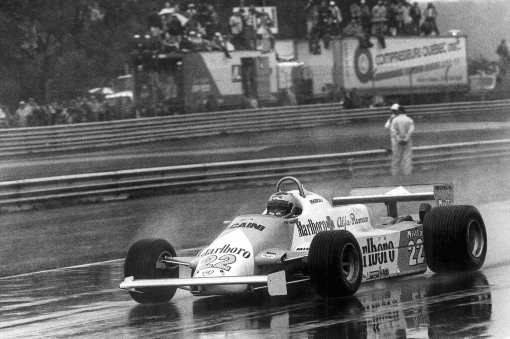 Mario Andretti racing an Alfa Romeo Formula One car in wet conditions