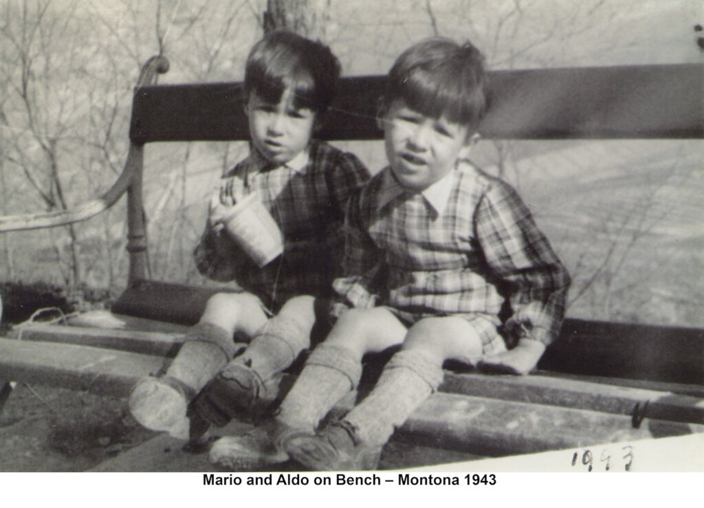 Mario Andretti and Aldo Andretti sitting on a bench in Montona in 1943