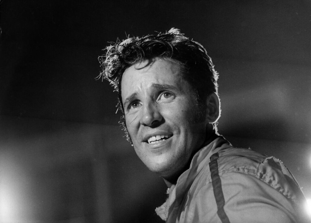 Black and white portrait of Mario Andretti smiling