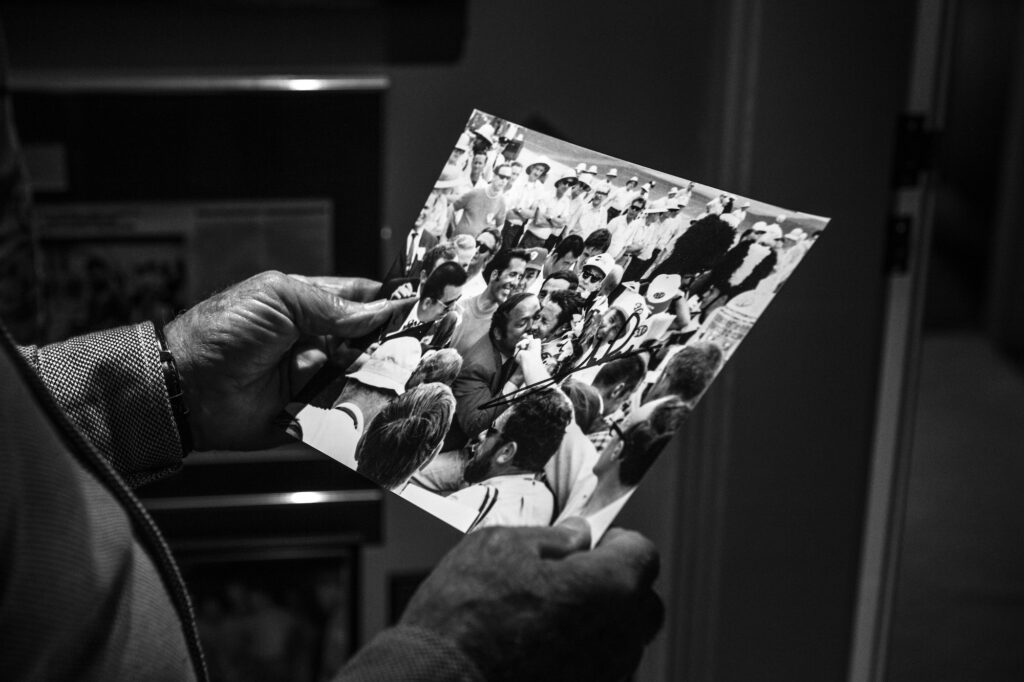 Mario Andretti holding a vintage racing photograph