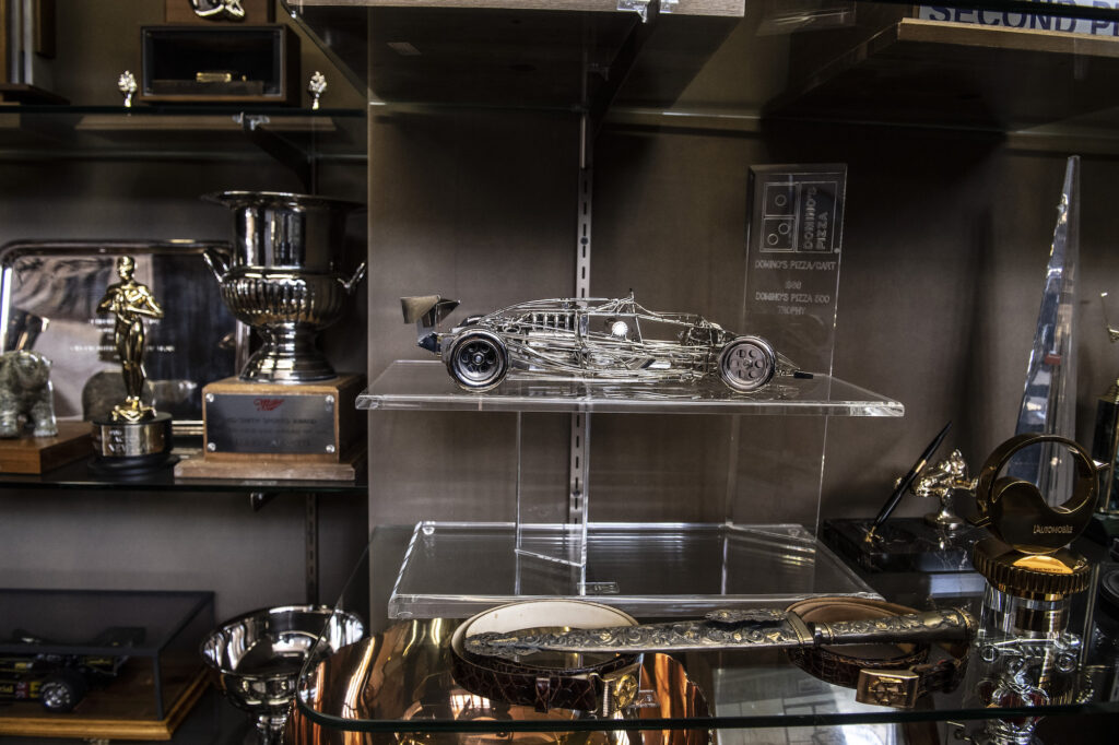 Model race car and trophies displayed in Mario Andretti’s collection