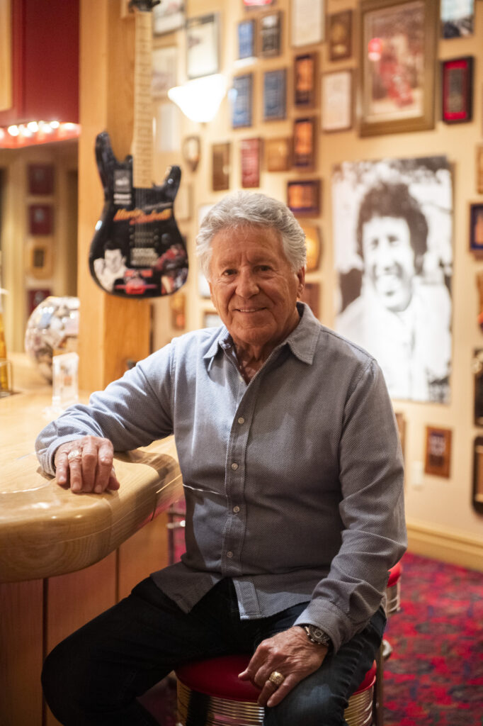 Mario Andretti seated in his trophy room