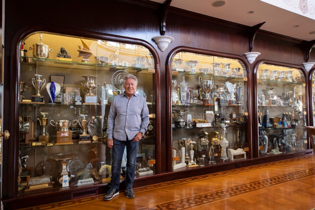 Mario Andretti standing in his trophy room
