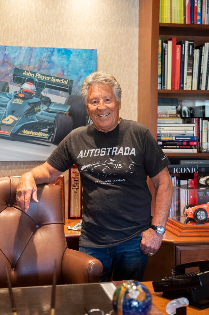 Mario Andretti standing portrait wearing an Autostrada shirt
