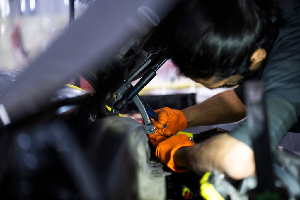 Hands working on ducktail installation at European Autoworks