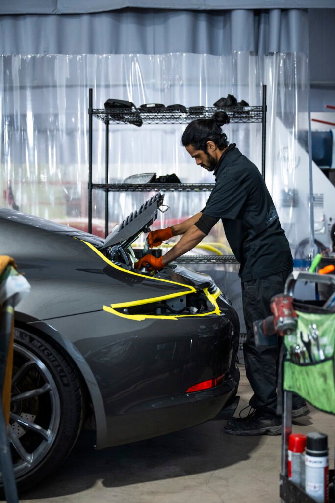 Technician working on ducktail installation at European Autoworks