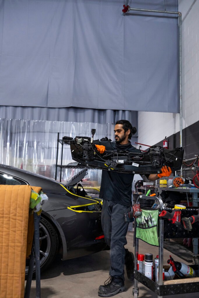 Ducktail installation technician working on Porsche 911 Carrera GTS