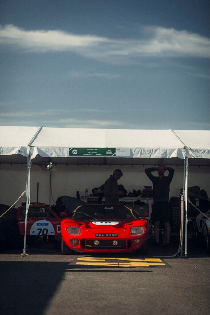 Red Ford GT40 parked beneath a paddock tent at Classic Le Mans