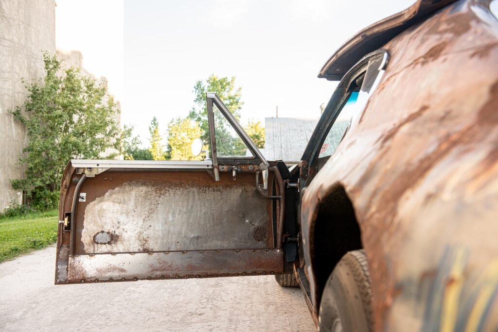 Open door showing rusted patina bodywork on vintage Chevrolet Chevelle