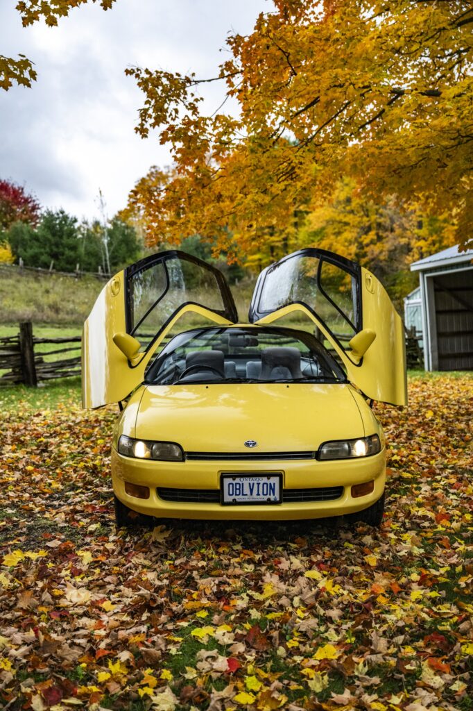 Yellow Toyota Sera head-on view with butterfly doors open