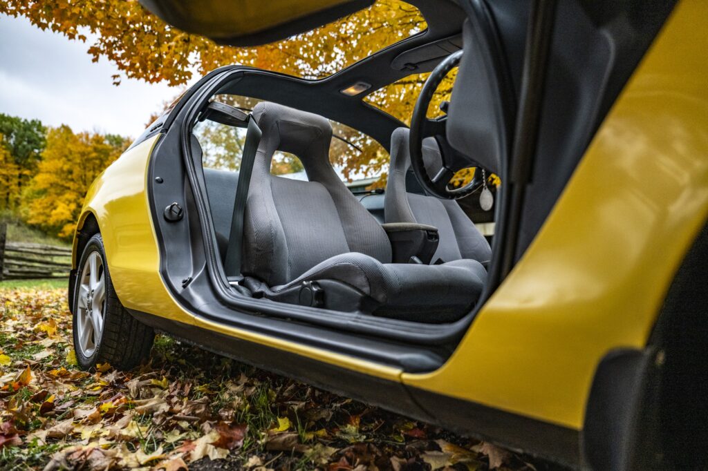 Interior view from side of yellow Toyota Sera with butterfly door open