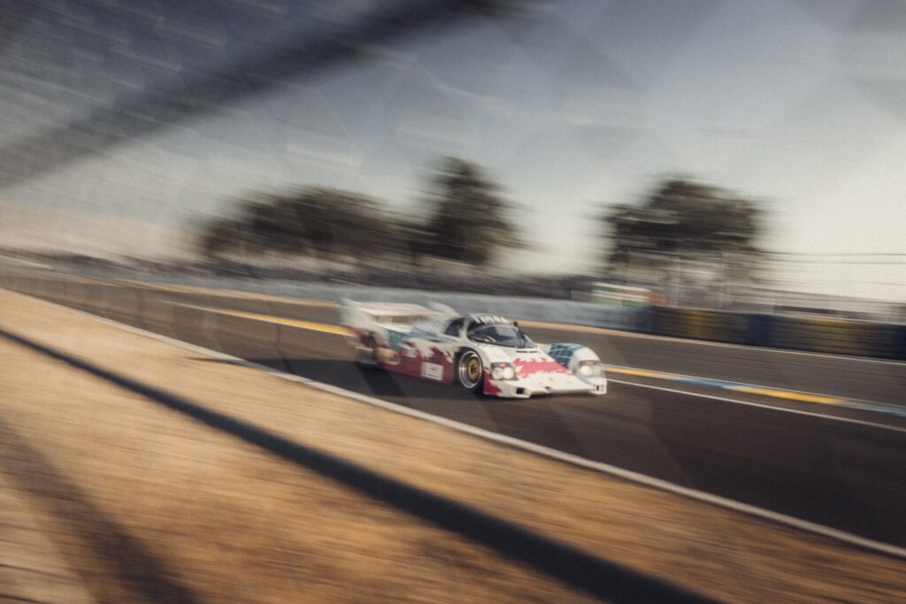 White and pink prototype race car in motion at Peter Auto Classic Le Mans