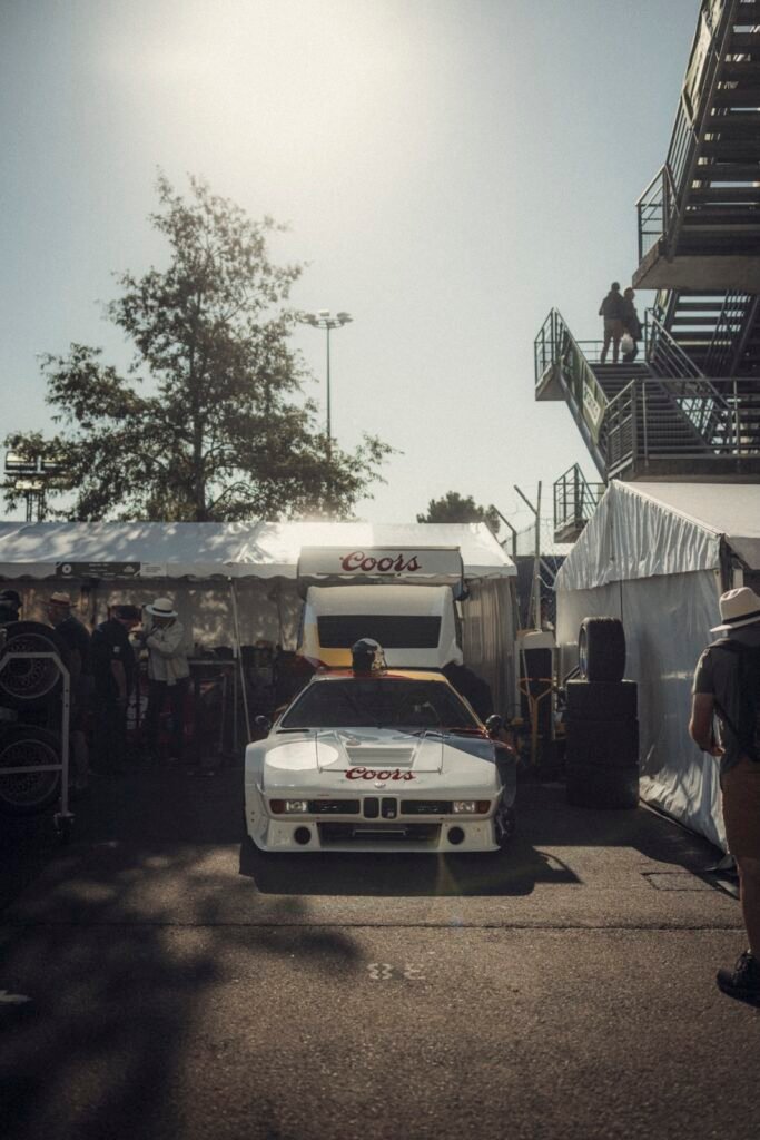 White BMW race car with Coors branding in the paddock at Classic Le Mans